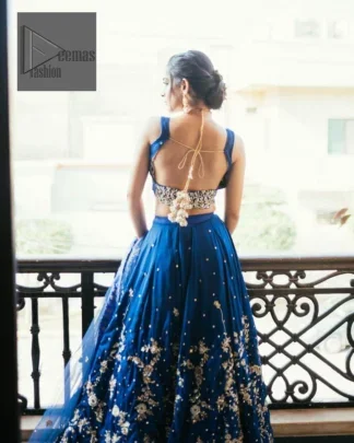 The Royal blue blouse is adorned with silver embroidery, making it a head-turning masterpiece. Moreover, the square neckline is fully embellished with tilla, dabka, kora, Kundan, and pearls, lending it a magical appearance.