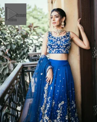 The sleeveless style adds a touch of allure to this already captivating outfit. It is paired with an embroidered lehenga to enhance your day's look, and the article is completed with a dupatta featuring tiny floral motifs and sequins sprayed all over.