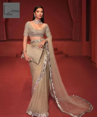Further, it comes with a half-sleeved style to give a royal touch. Its round neckline is just the epitome of grace. It is paired up with a saree in the same color having sequins spray all over to make a true statement.