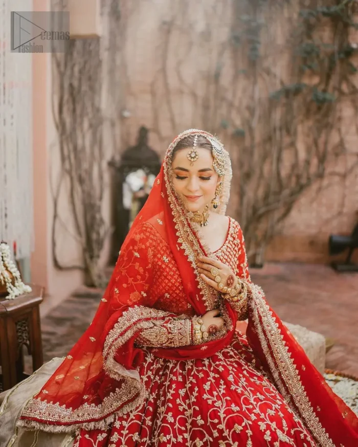 Step into your reception with confidence and poise in our exceptional red reception outfit, a true embodiment of individuality. This unique dress is a masterpiece of design that involves light golden and bosky shades of embroidery having tilla, dabka, kora, Kundan, and Zardozi