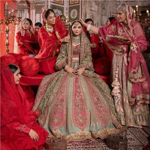 The flowing pistachio green lehenga, adorned with gotta work and applique, sways with every step, while the net dupatta adorned