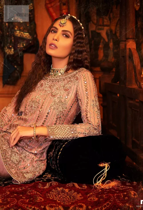 The soft salmon pink shade radiates a sense of femininity, while antique embroidery and mirror work weaves a tale of