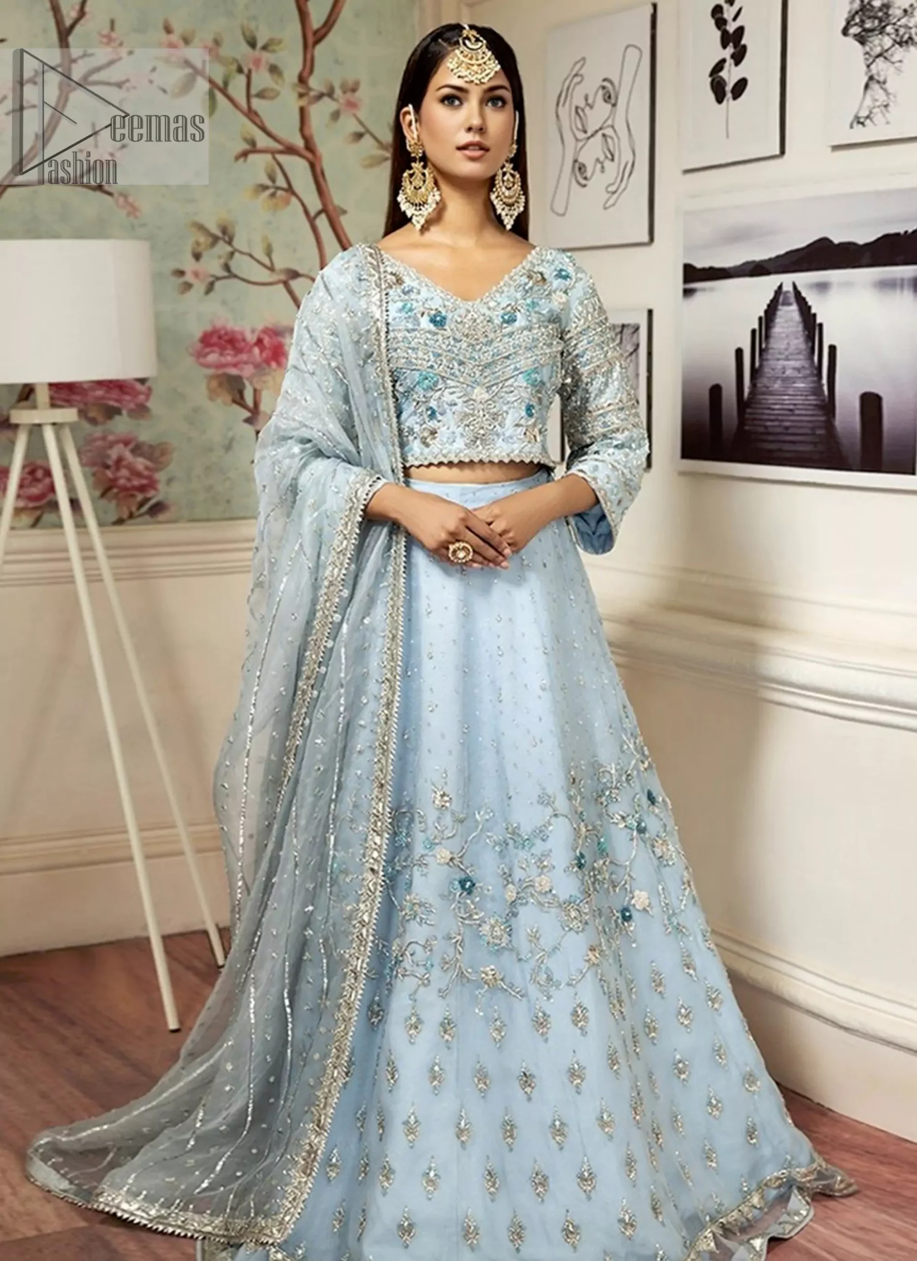 the flowing lehenga complements the overall regal look with scattered sequins and tiny floral motifs. Let your impeccable gorgeousness set the new beauty standards with the beautiful organza dupatta embellished with silver gotta stripes.