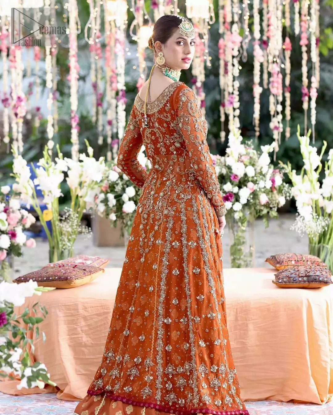The angrakha, spun in banarsi chiffon, glows under sculptured golden embroidery that moves like sunlight over silk. A farshi lehenga that’s regal in flow and texture trails beneath, and makes every layer sing the opulent grace.