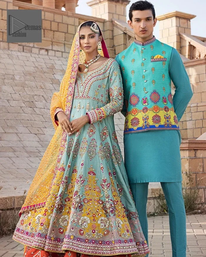 Effortlessly achieve the perfect bride look with this mehndi wear! Turquoise Frock is adorned with gorgeous motifs in multiple colors. It is further encrusted with the magic of gota, pitta, naqshi, Zardozi, tilla, and dabka along with sequins and pearls. The round neckline gives a traditional look to the outfit. Further, the tiny floral motifs also intensify the beauty of the masterpiece. This piece is paired up with an orange lehenga to make the contrast balance. Complete this outfit with a dupatta framed with four-sided borders to make your day versatile and charming.